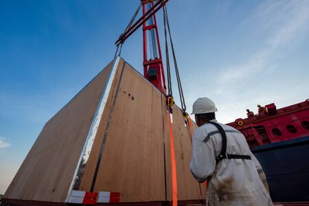 stevedore foreman or chief officer port loading master in charge handle loading heavy lift package unit under cranes of the ship, working under and at risk of  insurance の写真素材