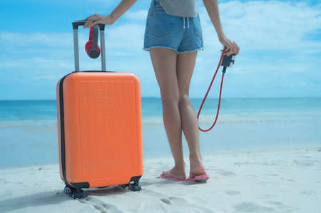 Woman tourist traveller standing on the sea beach ready going to the trip journey to explore the Worldの写真素材