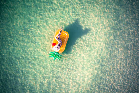 woman in bikini enjoy swimming on inflatable tube at the sea island, summertime enjoyment in the sea alone, weekend and vacation enjoyment in the sea summertimeの写真素材