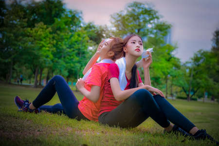 group of sporty women in motion of enjoy happiness take a resting after excercise jogging together in the morning of city street public park, enjoy healthy slim body in freshly morning together of young womanの写真素材