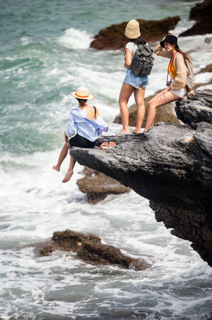 Group of women traveler enjoy the trip of hiking to the natural cliff in the sea, summer moment on trip travelingの写真素材