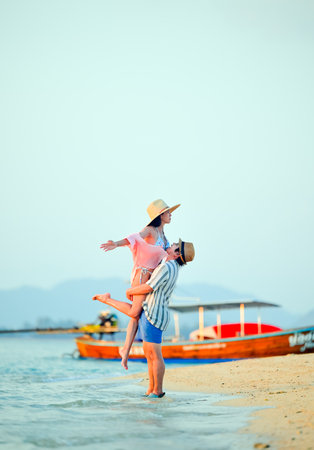 Couple traveler enjoy trip traveling together at the edge of the sea beach, summertime traveling together enjoymentの写真素材