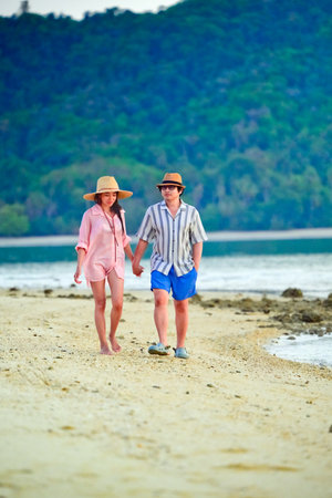 Couple traveler enjoy trip traveling together at the edge of the sea beach, summertime traveling together enjoymentの写真素材