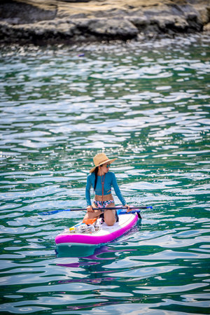 Woman tourist  paddle board at the sea summer, vacation long weekend traveling in islandの写真素材