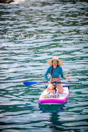 Woman tourist  paddle board at the sea summer, vacation long weekend traveling in islandの写真素材