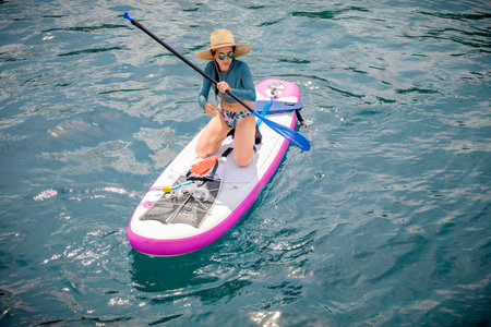Woman tourist  paddle board at the sea summer, vacation long weekend traveling in islandの写真素材