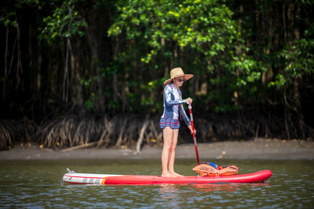 Women enjoy standup paddle board in the natural lake river of rainforestの写真素材