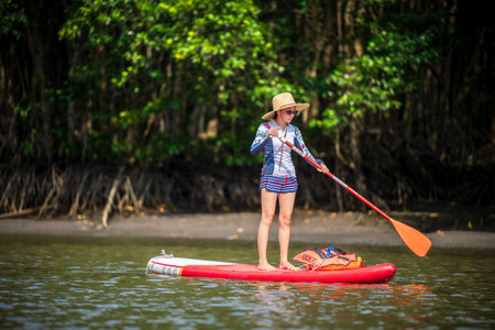 Women enjoy standup paddle board in the natural lake river of rainforestの写真素材
