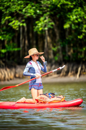 Women enjoy standup paddle board in the natural lake river of rainforestの写真素材