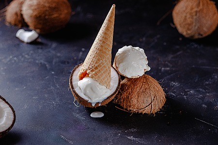 coconut ice cream in a waffle cone on a dark background, side view.の写真素材