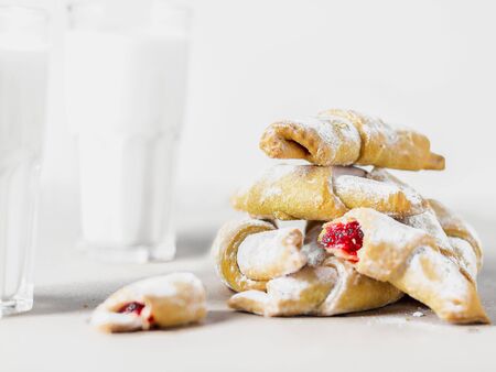 bagels in icing sugar on a white background, a glass with milk nearby, high keyの写真素材