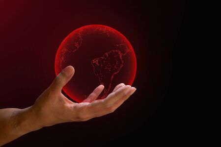 Global crisis concept. Transparent red earth on human hand on red and dark background. with copy space. World critical warming, corona virus from human.の写真素材