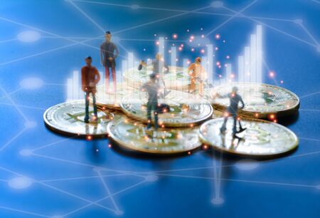 Miniature people teamworks, small model human figure standing and digging on golden Bitcoins with network conection line and garph. Cryptocurrency or digital money concept.の写真素材