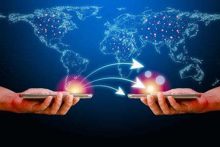 Hand holding smartphone with white curve graph and money from one device to another on a white world map and blue background. New normal of shopping online concept.の写真素材