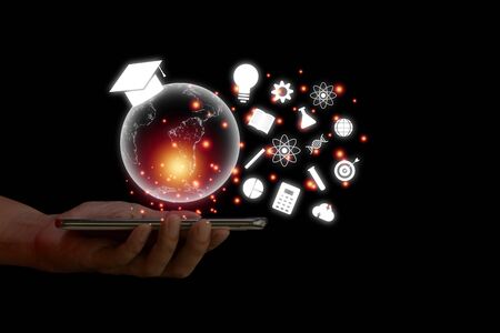 E-learning concept. Hand hold smartphone with  transparent earth and white education icon on black background.の写真素材