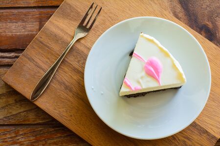 cheese pie cake in white plate and metal fork on wooden table.の写真素材