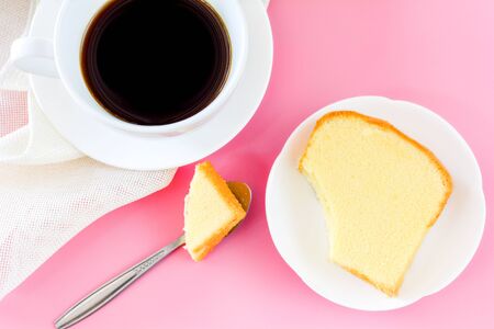 Piece of butter cake on white dish served with cup of black coffee. Times to relax concept.の写真素材