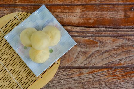 Top view. Thai style Mochi stack on white plate  and wooden table with copy space for your text. Thai sweet dessert.の写真素材