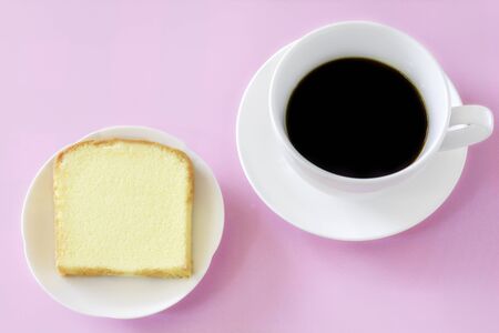 Piece of butter cake on white dish served with cup of black coffee. Times to relax concept.の写真素材