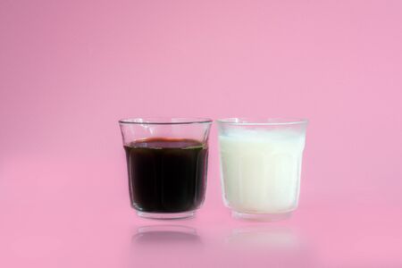 Glass of white and pink milk, black coffee on pink background. Beverage in morning concept.の写真素材