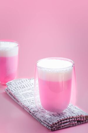 Summer drink concept. Strawberry pink milk with froth milk in clear glass on pink background.の写真素材