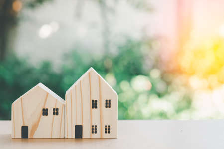 Eco home concept. Small wooden home model with green natural bokeh background with copy space.の写真素材