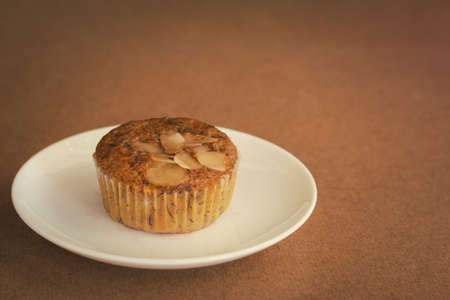 Delicious banana cup cake on white dish and wooden table with copy space. Homemade bakery.の写真素材