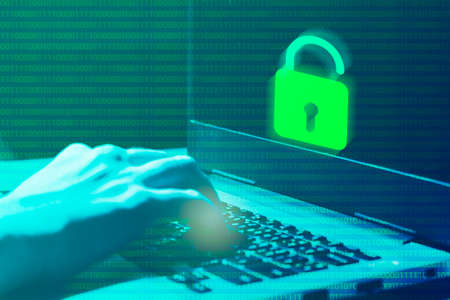 Cybercrime concepts The hacker's hand is on blurry computer or laptop background. Stolen data and use it for payments and shopping on laptop.の写真素材