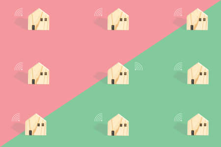Smart home concept. Group of little wooden home with white Wifi icon on half of pink and green background. Internet, connection, e-learning, and work from home backdrop.の写真素材