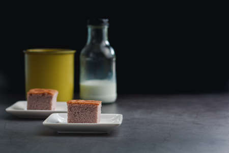 A square-cut of sweet potato cake on a white plate in the kitchen. Bakery and beverage concept.の写真素材