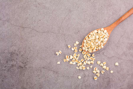 Vegan and healthy food concept. Job's tears with a wooden spoon on the black table. Top view.の写真素材