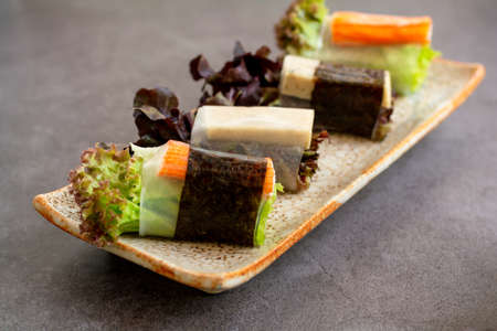 Healthy food concept. Salad roll made from fresh lettuce, seaweed, crab stick, and Vietnamese chicken wrap with rice vermicelli served with dipping sauce.の写真素材