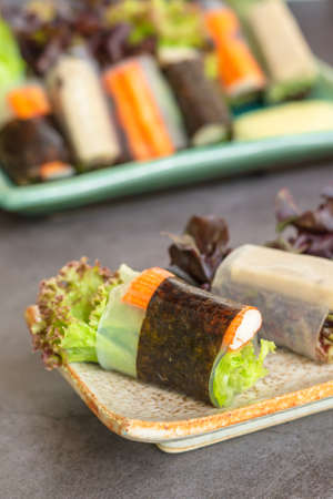 Healthy food concept. Salad roll made from fresh lettuce, seaweed, crab stick, and Vietnamese chicken wrap with rice vermicelli served with dipping sauce.の写真素材