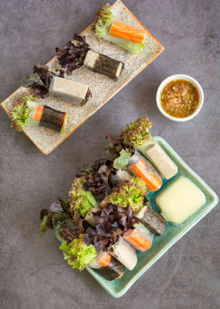 Healthy food concept. Salad roll made from fresh lettuce, seaweed, crab stick, and Vietnamese chicken wrap with rice vermicelli served with dipping sauce.の写真素材