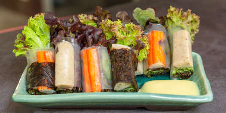 Healthy food concept. Salad roll made from fresh lettuce, seaweed, crab stick, and Vietnamese chicken wrap with rice vermicelli served with dipping sauce.の写真素材