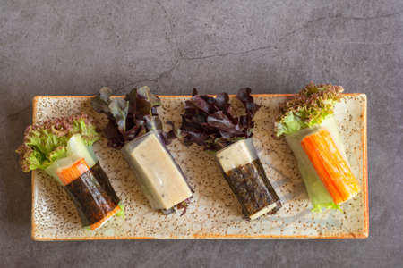 Healthy food concept. Salad roll made from fresh lettuce, seaweed, crab stick, and Vietnamese chicken wrap with rice vermicelli served with dipping sauce.の写真素材
