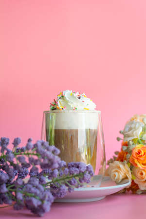 Ice coffee with a layer of milk and whipping cream with color sugar topping on pink background. Beverage and drink at the party concept.の写真素材