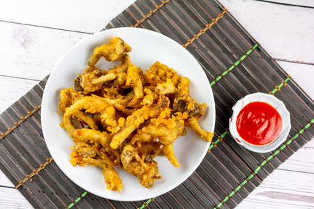 Snack food concept. Deep-fried crispy oyster mushroom on a white plate with red hot chili dipping sauce.の写真素材