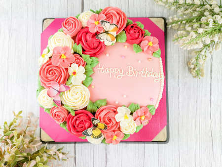 Beautiful homemade cake. Cake decorated with red and pink rose and flora with butterfly for birthday.の写真素材