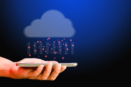 Cloud data storage concept. Hand hold cloud computing with transfer arrow on blue background. Communication of business and financial. Large database and synchronize with the internet and technology.の写真素材