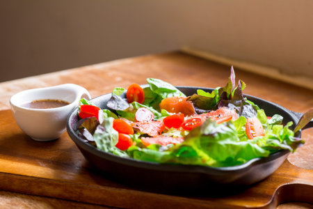 Smoke salmon Salad with green and red oak and cherry tomato served with sesame salad dressing. Homemade food. The concept for a tasty and healthy meal.の写真素材