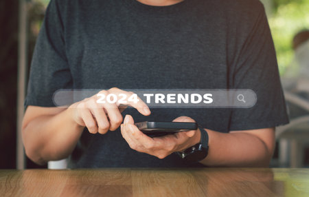 Business planning concept. Businessman use mobile phone or smartphone to search on searching bar with 2024 trends keyword for business marketing.の写真素材