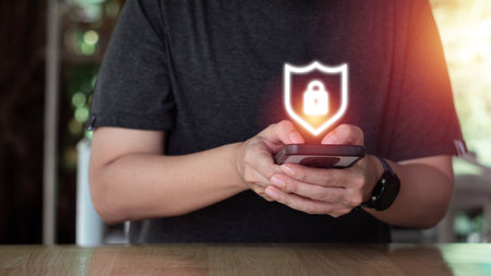Internet and cybersecurity concept. A businessman is protecting personal data on mobile or smartphone. Online financial errands, data transfer, communication, big data, a virtual lock icon.の写真素材