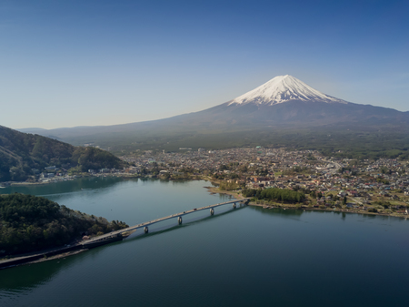 Mountain Fuji reflected in Kawaguchiko lake with city view from drone shot on a sunny day and clear skyの写真素材