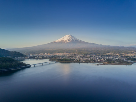 Mountain Fuji reflected in Kawaguchiko lake with city view from drone shot on a sunny day and clear skyの写真素材