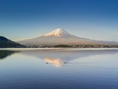 Mountain Fuji reflected in Kawaguchiko lake with city view from drone shot on a sunny day and clear skyの写真素材