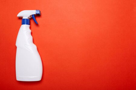 White bottle of spray for cleaning on red background. Top view. copy space for text.