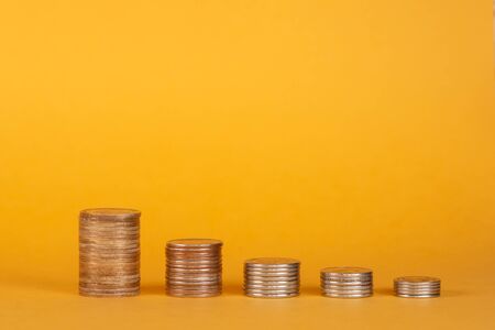 Stack of coins on a orange or yellow background