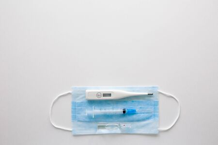medical mask on a black background.face mask. mask for diseases. Thermometer and medication. the...