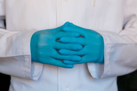 doctor close-up. Surgeon's medical gloves on black background.